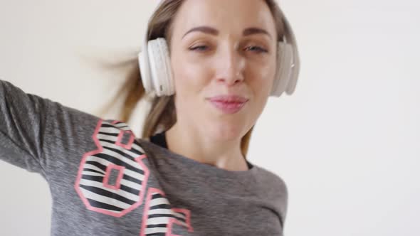 Joyful Pretty Girl in Headphones Dancing in Studio