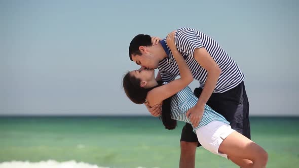 Young couple kissing on the beach by the sea