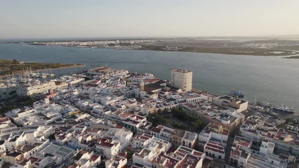 Ayamonte, Spain: Orbiting shot above traditional white buildings on seaside. Aerial View