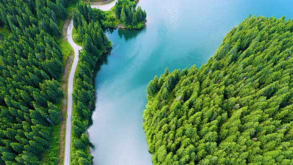 Aerial view over beautiful turquoise mountain lake and green forest. Summer in the mountains.