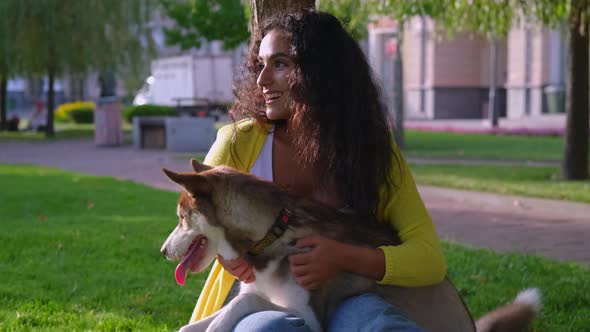 Happy Woman is Stroking His Cute Husky Dog in Park