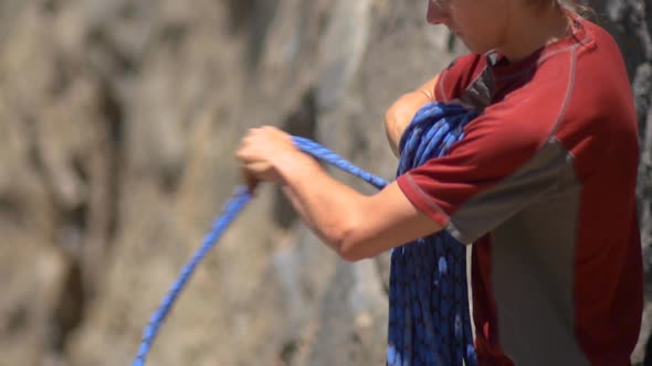 A young man preparing his rope before going rock climbing.