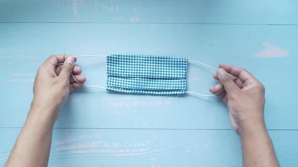 Hand Holding Zero Waste Homemade Face Masks on Table