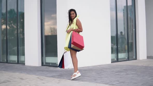 Beautiful Girl Model After Shopping with Colored Bags in Hands