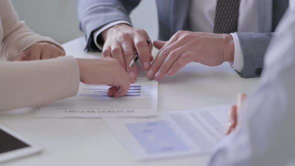 Close up of Hands of Businessman with Female Colleagues Discussing Documents