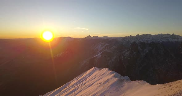 Aerial drone view of snow covered Alps mountains in the winter at sunset