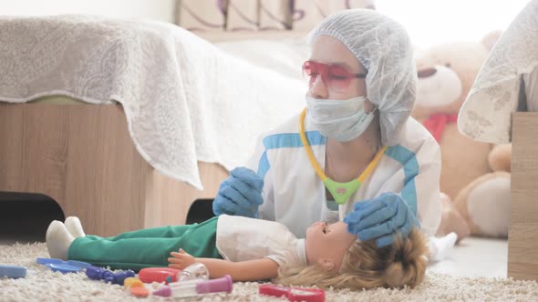 Beautiful Little Girl Playing Doctors with Doll at Home