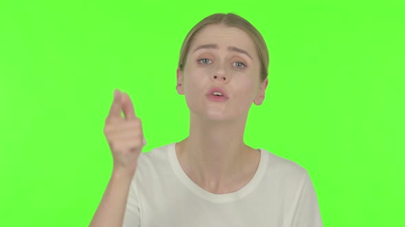 Angry Young Woman Arguing on Green Background