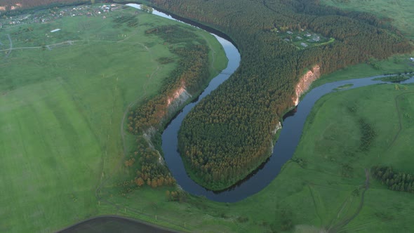 Aerial View of the River with a Rock and Forest on the Banks