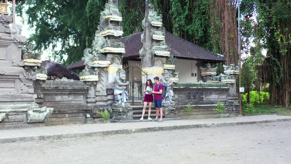 Young tourists reading a brochure while exploring an ancient city full of history