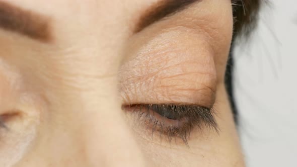 Make Up Artist Do Eye Makeup to Middleaged Woman with Blue Eyes