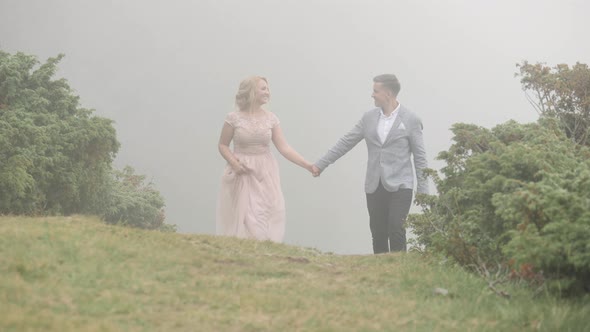 Elegant couple walking on a hill