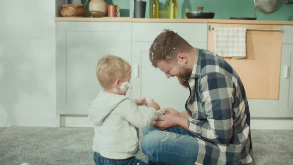 Father and Son Playing on Floor with Shaving Foam