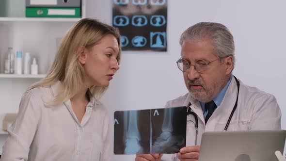 Doctor Consults Patient By Showing Her Picture of Leg and Discusses Treatment of Disease with Her