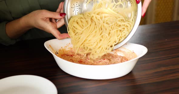 Step by step woman cooking feta cheese pasta, pours out spaghetti