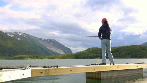 Woman Fishing on Fishing Rod Spinning in Norway