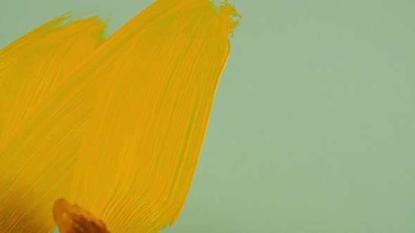 Yellow Acrylic Paint on a Green Background