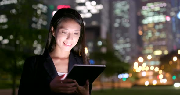 Businesswoman use of tablet computer at night