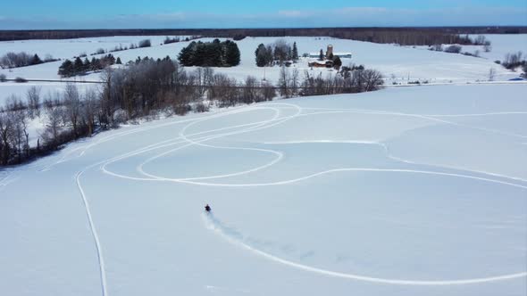 snowbike aerial rider carving the open fields and hills in fresh powder