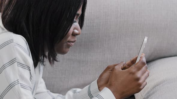 Headshot Closeup Young Carefree African American Woman Lying on Sofa Holding Smartphone Resting in