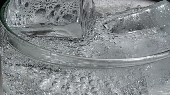 Glass of Water with Ice on a Dark Blue Background