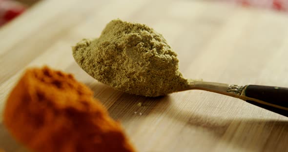 Turmeric powder, ed chili powder and coriander powder on a wooden table 4k