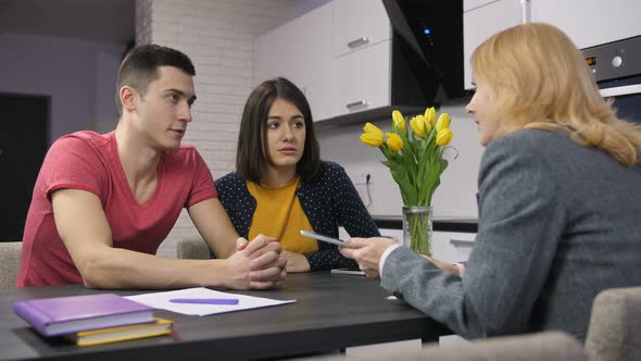 Young Couple Talking To Agent About Mortgage