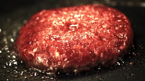 Super Slow Motion Burger Patty is Fried with Bubbles of Oil in a Frying Pan