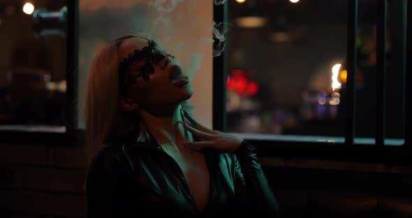 Sexy Woman Smoking Hookah in Night Bar
