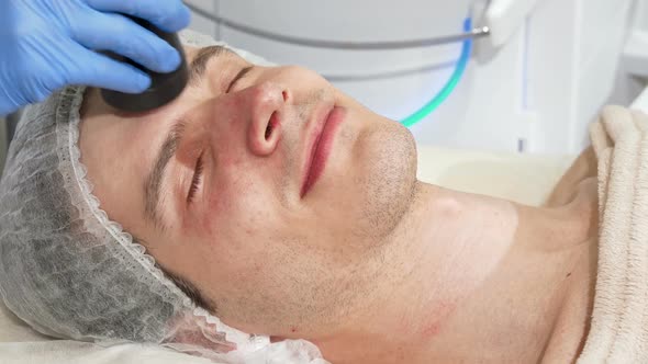 Man Receiving Facial Ultrasound Cavitation Treatment By Cosmetologist