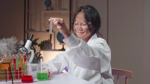 Young Asian Scientist Girl With Dirty Face Mixes Chemicals In Test Tube. Child Learn With Interest