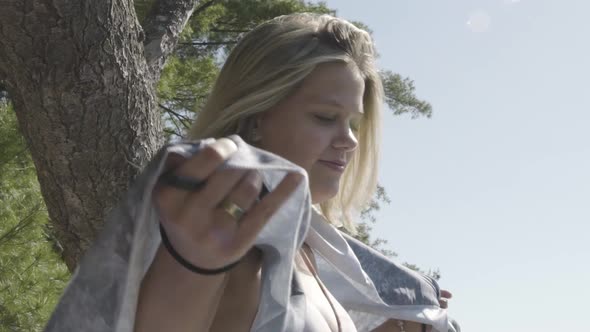 Happy young millenial woman outdoor in nature looks behind on sunny day at beach, closeup, slow moti