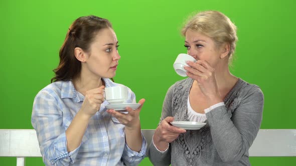 Two Women Drink Tea and Talk. Green Screen