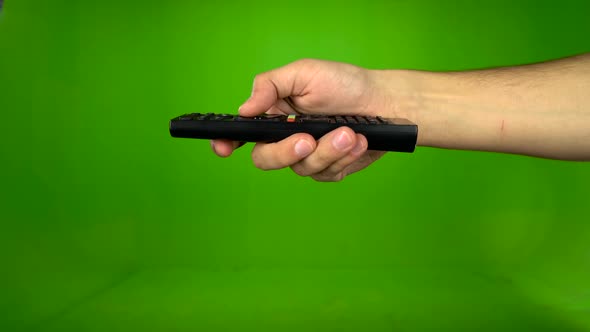 Male Hand Operating a Tv Remote Control on a Green Screen. Green Screen. Side View