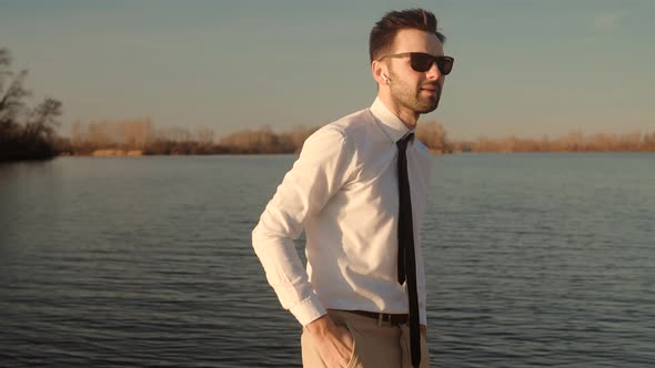 Cheerful Man Relaxing And Using Wireless Headphones And Listening Music From Smartphone On Nature.