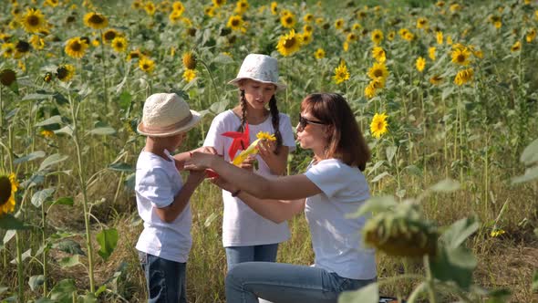 Kids with Mother Having Fun in Sunflower Field