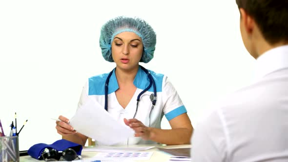 Doctor Sitting at the Table Explains Diagnosis of a Young Woman White Background