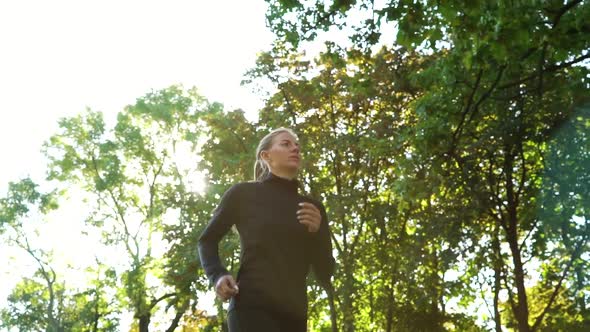 Female Jogger Running Under Trees on Sunny Day