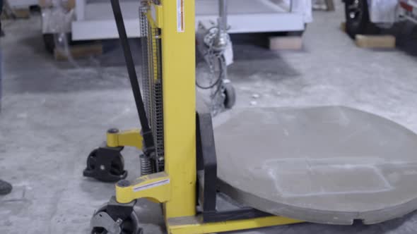 Worker lifting a circular concrete form on forklift