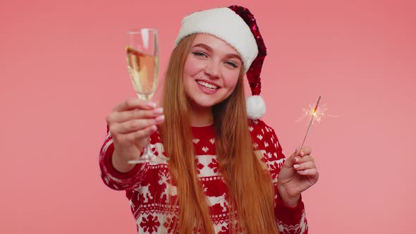 Lovely Girl in Christmas Santa Sweater Dancing with Bengal Sparklers Fireworks and Champagne Glass