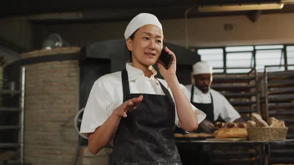 Animation of happy asian female baker having call