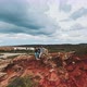 Zooming out shot by drone featuring two men sitting on top of the cliffs and hugging - VideoHive Item for Sale