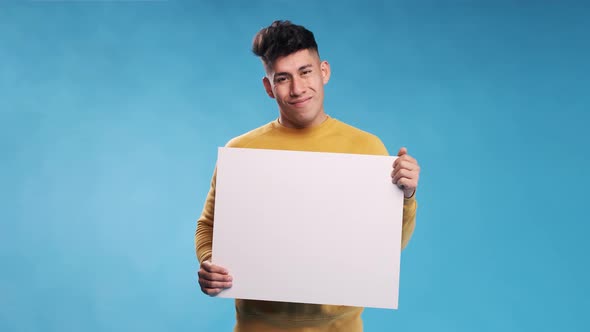 Man looking at camera and smiles while holding blank white sign over an isolated background