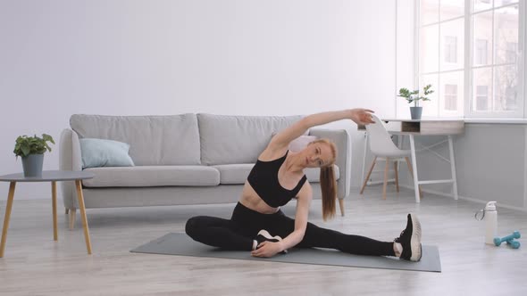 Fitness Lady Doing Half Split Side Bend Stretching Body Indoors