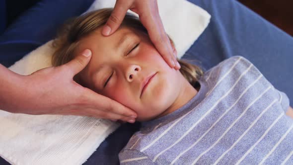 Physiotherapist giving head massage to a boy