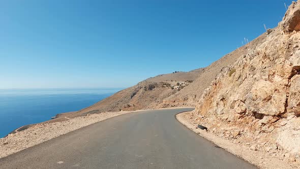 Coast POV driving in the mountains on a sunny summer day. Zig-zag curve road and U-turns in a desert