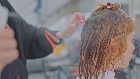 Close up of professional stylist or hairdresser spraying and making water drop on customer's hair.