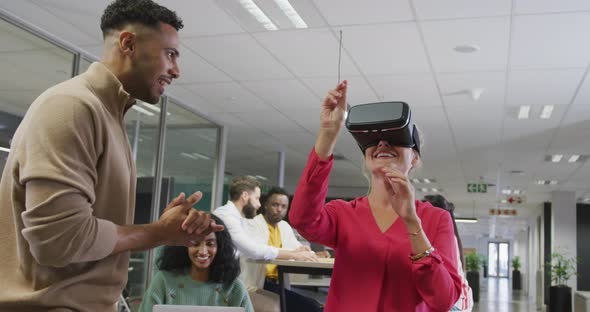 Happy diverse male and female business colleagues using vr headset in office