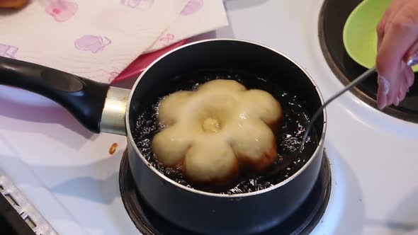A Woman Fries A Donut In The Form Of A Flower In Boiling Oil. Preparing Donuts In The Form Of A Flow