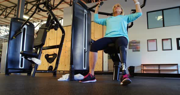 Senior woman doing exercise on chest press machine 4k